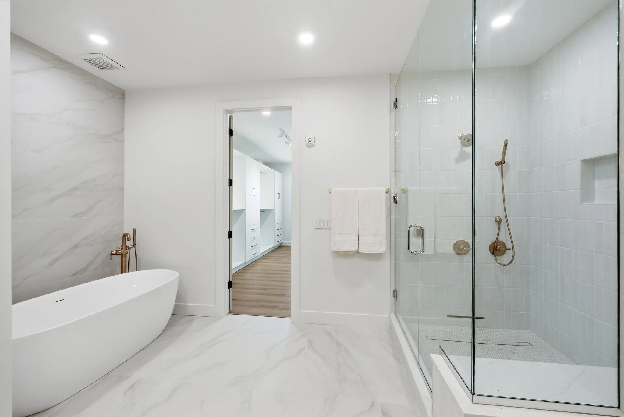 Primary bathroom with marble shower and freestanding soaking tub