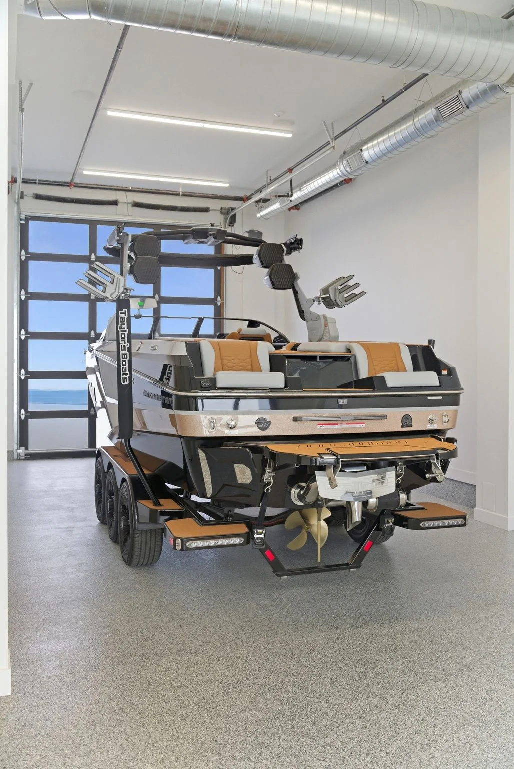 Drive-through garage with 20-foot ceilings storing a boat on a trailer